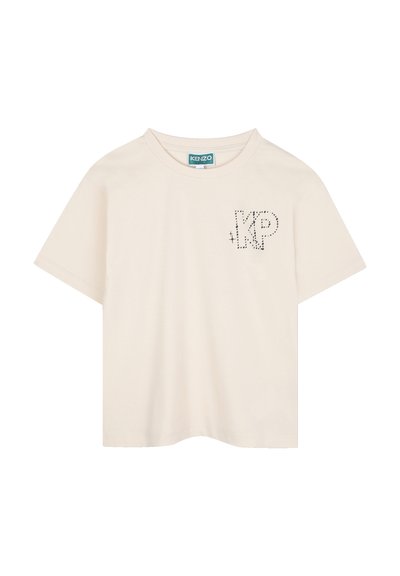 T-shirt en coton beige à manches courtes avec un design "KP" en points noirs sur la partie gauche de la poitrine. Col rond classique, coupe décontractée.