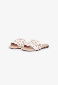 Infradito intrecciati realizzati in un mix di materiale sintetico bianco e beige, con suole piatte e un design open-toe con una finitura testurizzata.