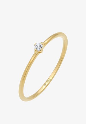 Guldbelagt ring med en enkelt rund klar sten i en 4-prong setting, simpel bånddesign, og stemplet med "925" for sterlingsølv.