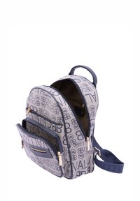 Zaino a righe blu navy e beige con hardware dorato, numerose tasche con zip, design ergonomico e tessuto resistente.