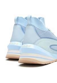 Zapatillas deportivas azul claro con materiales de malla y cuero, forma redondeada, detalles en blanco y una suela de goma texturizada.