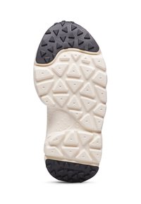 Suola di una scarpa con una superficie testurizzata e lugs triangolari, colore crema con un accento nero e branding sul tallone.