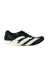 Scarpa da corsa Adidas Adizero Adios 9 in bianco e nero con audaci strisce bianche e una suola a profilo basso, vista di lato.