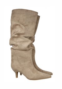 Botas altas de ante beiges con un diseño arrugado, punta afilada y un tacón de tres pulgadas. Textura suave con un detalle mínimo.