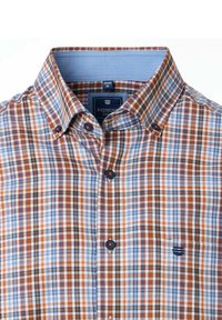 Heren overhemden met een blauw, oranje en bruin geblokt patroon en een contrasterende lichtblauwe binnenkraag, merklabel zichtbaar.