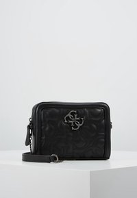 Czarna skórzana torba crossbody o pikowanej fakturze, z wytłoczonym logo, srebrnymi akcesoriami i odpinanym paskiem. Prostokątny kształt.