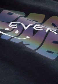 Schwarzer Stoff mit auffälligem, mehrfarbigem Text, der "Best Ever" in einer fröhlichen Schriftart zeigt, ergänzt von einem Smiley. Der Stoff hat eine glatte Textur.