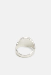 Anel de prata com um design suave e arredondado e um acabamento polido. O interior é ligeiramente texturizado, proporcionando um contraste subtil.