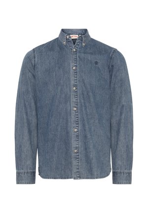 Denimskjorte med krage og knapper, lange ermer og logo på brystet. Stoffet er mellomblått med en jevn tekstur og stitch-dekorasjoner.