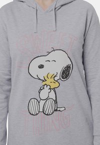 Felpa grigia con cappuccio caratterizzata da un'illustrazione stampata di Snoopy che tiene Woodstock, con la scritta "SWEET THING" in rosa. Tessuto morbido, vestibilità comoda.