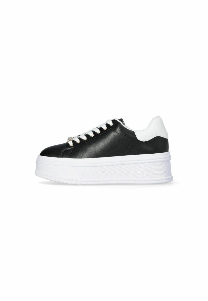 Baskets à plateforme noir et blanc avec une semelle blanche épaisse, des lacets blancs et un col de talon blanc, vues de profil sur un fond blanc.