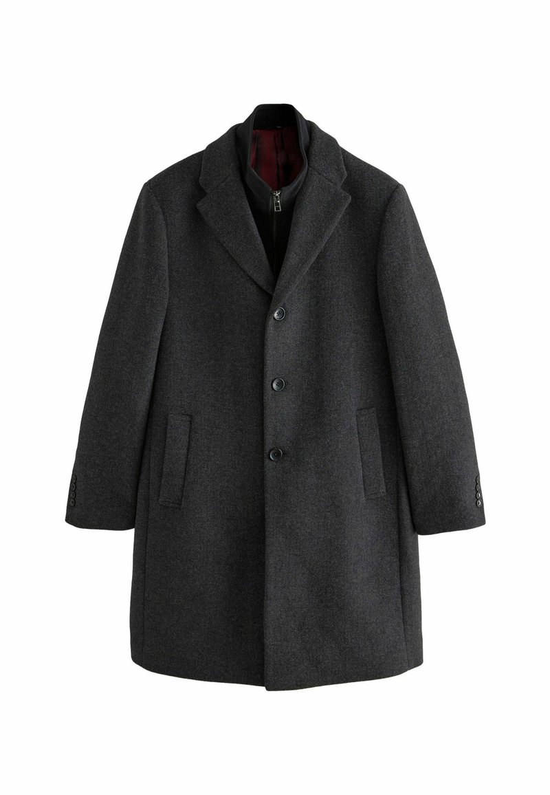 Abrigo de lana gris oscuro con solapa de muesca, tres botones, dos bolsillos delanteros y una tela texturizada. Forro interior en rojo oscuro.