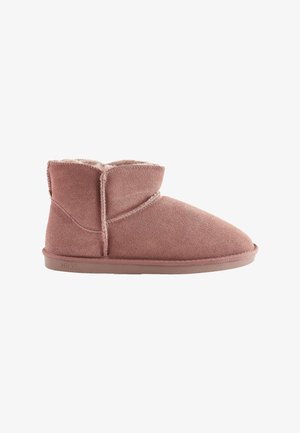 Stivali alla caviglia in suede rosa con morbida fodera, punta arrotondata e dettagli cuciti. Suola piatta in gomma con il nome del marchio in evidenza.