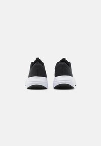 Zwarte sportieve schoenen met een textuur bovenkant van stof, witte tussenzool en zwarte buitenzool. Voorzien van een trekband aan de hiel.