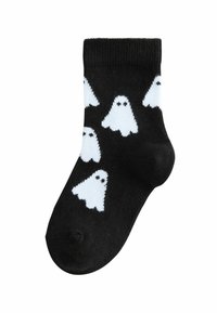 Schwarze Baumwollsocke mit weißen Gespenstermustern und schwarzen Augen. Gerippter Bund oben. Solide schwarze Fußsohle mit kontrastierendem Design.