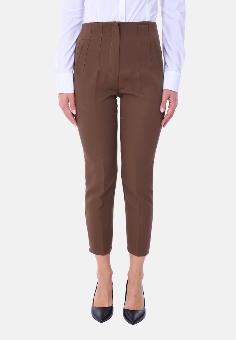 Pantaloni marroni sartoriali con vita alta, caratterizzati da pieghe frontali, tasche laterali e lunghezza cropped, abbinati a tacchi neri.