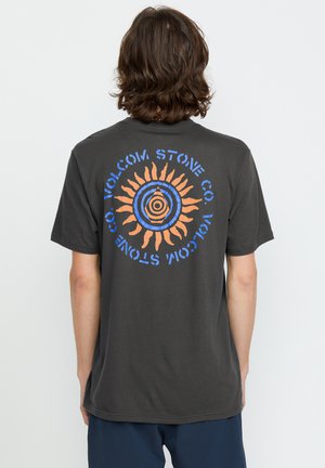 Donkergrijze katoenen t-shirt met een cirkelvormige grafiek in blauw en oranje, met een zonontwerp met stralen en de tekst "VOLCOM STONE CO."
