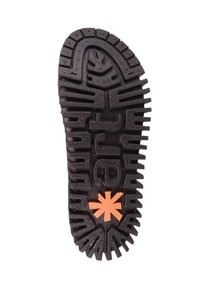 Semelle de chaussure en caoutchouc noir avec une surface texturée, présentant de profondes rainures et un accent en forme d'étoile orange vif au centre.
