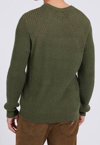 Olivgrüner, gerippter Strickpullover mit Raglanärmeln und runder Ausschnitt; strukturiertes Gewebe mit enganliegenden Bündchen und Saum.