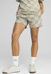 Lichtgroene patroonshorts van zacht materiaal, met een elastische tailleband en zijzakken. Gecombineerd met witte sneakers en merksokken.