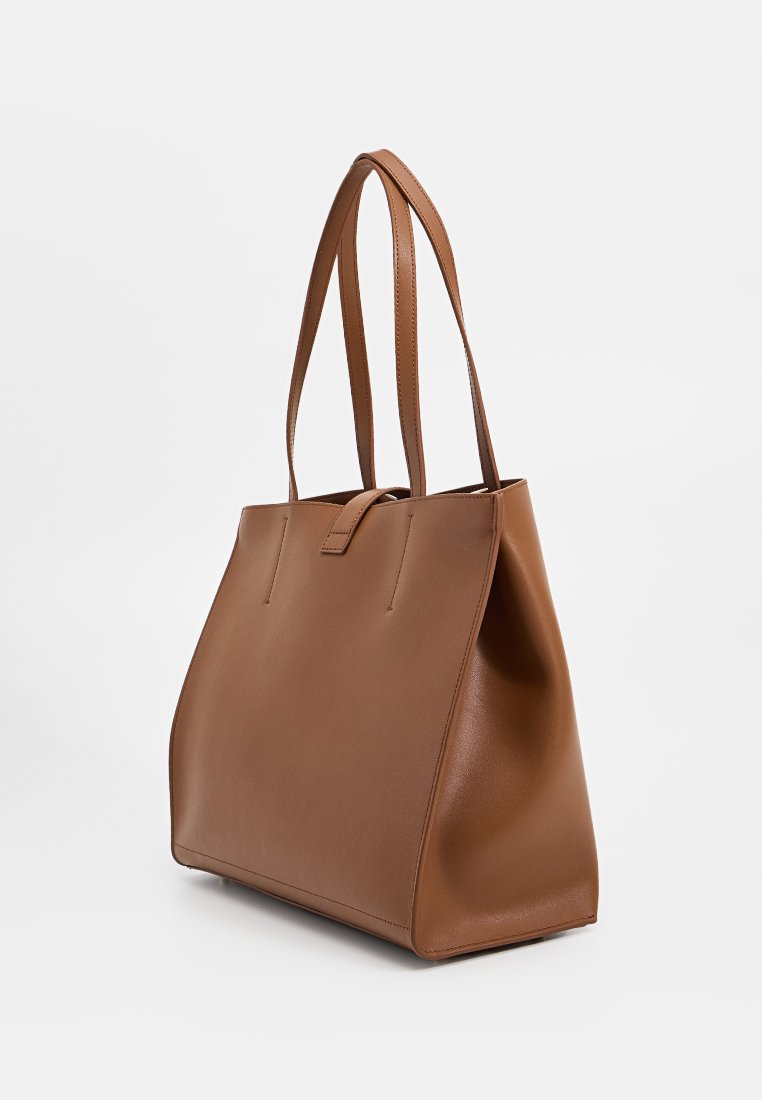 Brązowa skórzana torba na ramię o zorganizowanej konstrukcji, wydłużonych uchwytach i minimalistycznym wyglądzie. Gładka tekstura z subtelnymi detalami w szyciu.