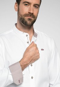 Witte button-up shirt met een staande kraag, voorzien van een contrasterende maroon kraag met patroon en knoopsieraden. Glad textuur, getailleerde pasvorm.