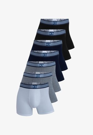 Smilende veltrænet mand stående iført hvide boxershorts med en blå linning mærket "CR7" mod en ensfarvet lysegrå baggrund.