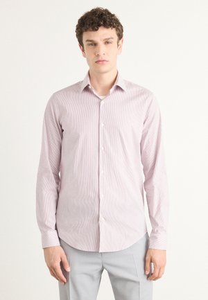 Camisa de botones en rosa claro con rayas verticales blancas, de manga larga y con dobladillo curvado. La tela parece suave con una textura sutil.