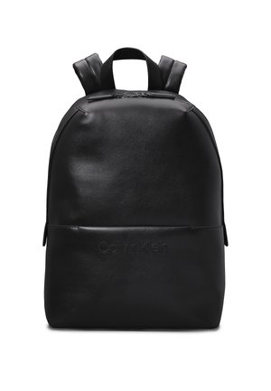 Zaino in pelle nera con forma arrotondata, dotato di spallacci regolabili e tasca con zip frontale. "Calvin Klein" impresso sul davanti.