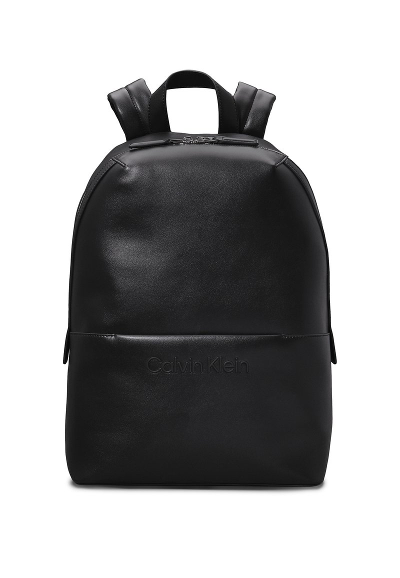 Zaino in pelle nera con forma arrotondata, dotato di spallacci regolabili e tasca con zip frontale. "Calvin Klein" impresso sul davanti.