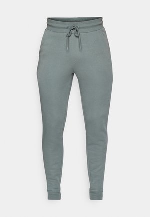Pantaloni jogging grigi realizzati in tessuto morbido, con vita elastica dotata di cordoncino e design a gamba affusolata. Inclusi due taschini laterali.