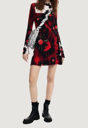 Rode jurk met bloemenpatroon en lange mouwen, een ronde hals, gecombineerd met een zilveren tas en zwarte enkellaarsjes.