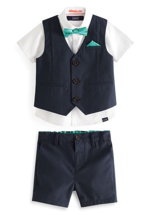 Vest bleumarin cu patru nasturi peste o cămașă albă, asortat cu pantaloni scurți bleumarin. Include o cravată verde și un batiste cu un model abstract.