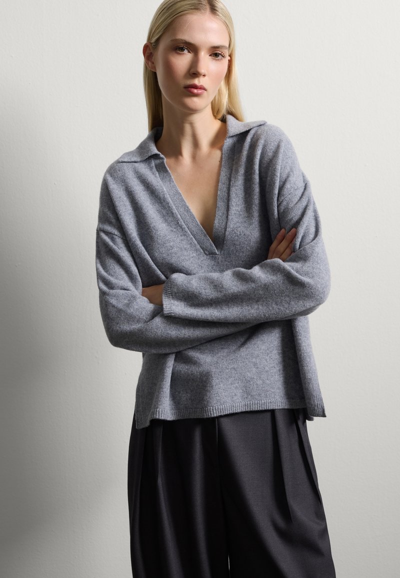 Grau, leichtes Sweatshirt mit V-Ausschnitt und Kragen, langen, lockeren Ärmeln und entspanntem Schnitt. Glatte Textur und minimalistisches Design.