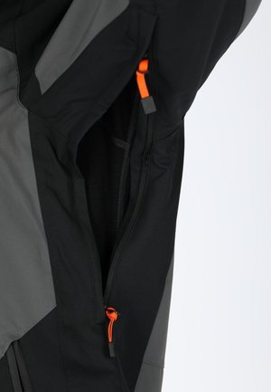 Schwarze und graue Jacke mit einem orangefarbenen Reißverschlusszug. Das Material wirkt leicht mit glatter Textur und strukturiertem Design.