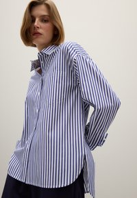 Blauw-wit gestreepte button-up shirt met een borstzak, lange mouwen, afgeronde zoom en een relaxte pasvorm. Gemaakt van lichtgewicht stof.