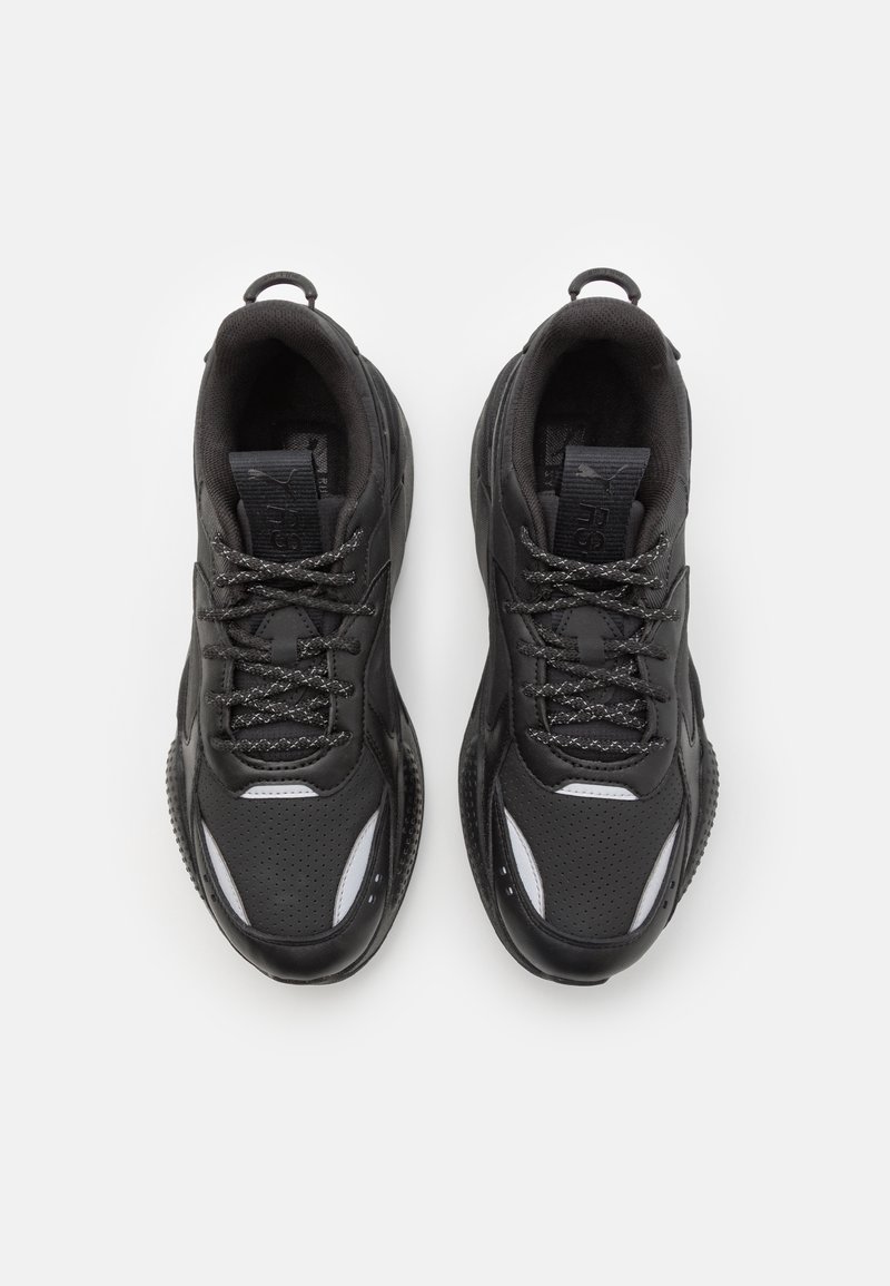 Paire de baskets de sport noires avec des accents blancs réfléchissants, des lacets tressés et des languettes de maintien, vues de dessus sur un fond blanc.