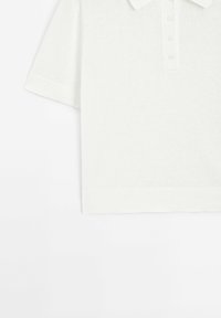 Lyhythihainen polo-paita vaaleassa kerma värissä, neulottu pinta, jossa on nappilista ja joustavat hihansuut sekä helmavarsi. Yksinkertainen ja siisti muotoilu.