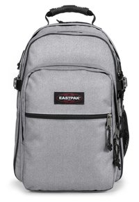 Grå Eastpak ryggsäck, tillverkad av vävt tyg, har en framficka med dragkedja, sidoficka i nät och vadderade axelremmar för komfort.