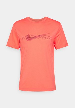 Korallenrotes Nike Pro Sport-T-Shirt mit kurzen Ärmeln, rundem Ausschnitt und dunkelrotem Nike-Swoosh sowie dem Text „Nike Pro“ in der vorderen Mitte.