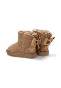 Botas de tobillo de ante marrón con forro de suave pelo, que presentan un lazo decorativo en la parte posterior y una suela de goma texturizada para mayor agarre.