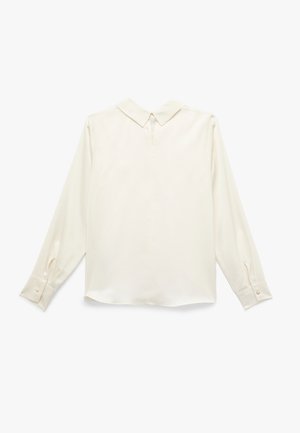 Blusa a maniche lunghe color crema realizzata in tessuto liscio, con colletto a punta, polsi abbottonati e un leggero luccichio. Fit sagomato con orlo dritto.