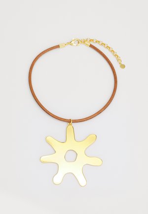 Collana in pelle con un cordino marrone rotondo e un grande pendente a forma di spruzzo dorato lucido con un ritaglio centrale.