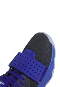 Lila Sport- Schuh mit einem perforierten Riemen, schwarzem Mesh-Obermaterial, strukturiertem Überzug und einer gemusterten Gummisohle. Verfügt über kontrastierende blaue Akzente.