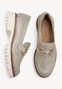 Lichtgrijze loafers van metallic leer met een rubberen zool. Heeft een decoratieve gesp in goudkleur en subtiele stiksels.
