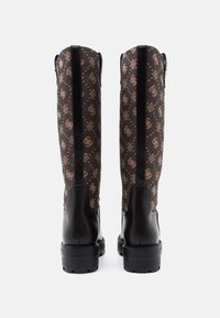 Botas negras hasta la rodilla con un tubo de tela marrón estampado, que presenta un diseño de logo y detalles en cuero negro. Suelas de goma planas.