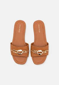 Bruna slidesandaler med en bred rem som har en guldkedjad accent. Slät textur och rektangulär form, med kontrasterande sömdetaljer.