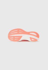 Semelle de chaussure avec un fond en caoutchouc rose, un motif texturé, des accents blancs et des rainures pour la traction.