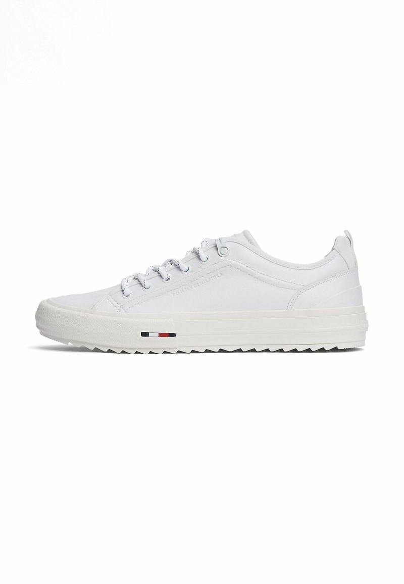 Sneaker bianche con tomaia in pelle texture, chiusura con lacci e un dettaglio a strisce rosso, bianco e blu sul lato. Suola in gomma.