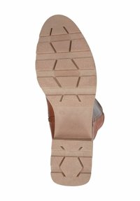 Hnědá kožená podrážka s texturovaným gripem. Hexagonální a lineární vzory, mírně vyvýšené sekce, měřící 4,5, s béžovou mezipodešví.